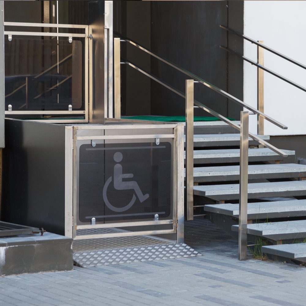 Motorized wheelchair lift next to a staircase Motorized wheelchair lift next to a staircase
